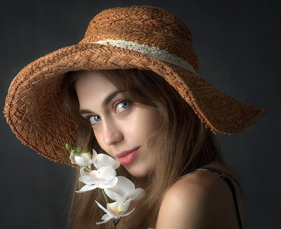 Attractive Female with White Flowers Wearing Brown Wide-Brimmed Hat