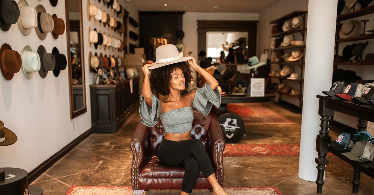Woman Trying on Beige Hat in Nice Hat Store